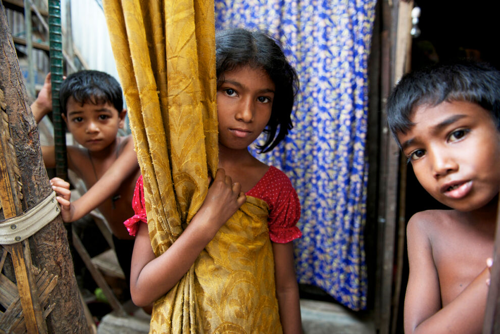 Laboni, 10, seisoo kotinsa oviaukolla Bangladeshin pääkaupungin Dhakan slummissa. Hän käy kolmatta luokkaa UNICEFin kumppanuusjärjestön koulua, joka on tarkoitettu äärimmäisestä köyhyydestä eläville lapsille. © UNICEF/UNI142699/Noorani