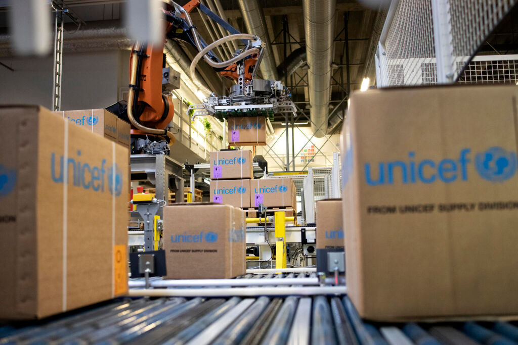 Unicefin tavaralaatikot liukuhihnalla.