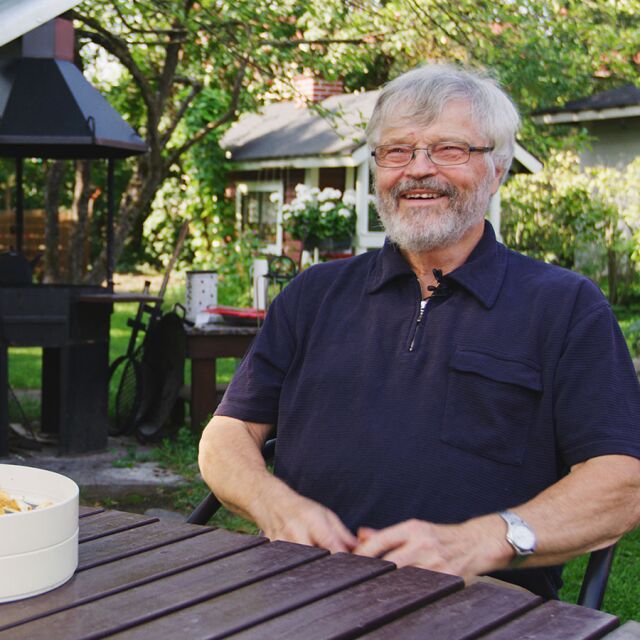 Markku sitter i trädgården.