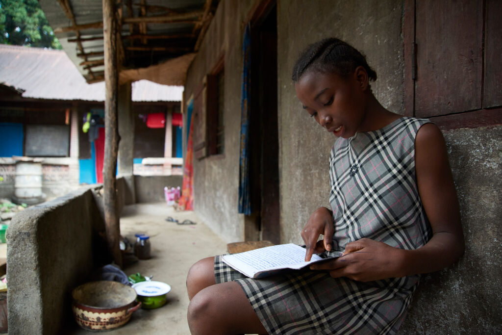 12-vuotias Mabinity Kamara tekee läksyjä kotonaan Tonokolilin alueella. "Lempiaineeni on matematiikka. Se on minulle helppoa". ©UNICEF/UN065170/Phelps