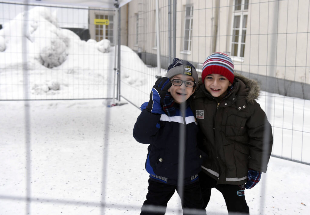 Palestiinasta kotoisin oleva Hamza (vasemmalla) ja syyrialainen Rony leikkivät aidatulla tupakkapaikalla turvapaikanhakijoiden järjestelykeskuksessa Torniossa tammikuussa 2016. © Lehtikuva/Jussi Nukari