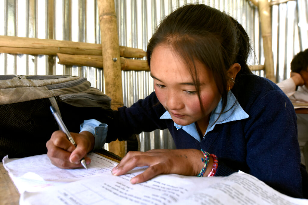 Kareena Tamang, 15, koulutöiden parissa Dhunchessa, Nepalissa. © UNICEF/UN04380/Karki