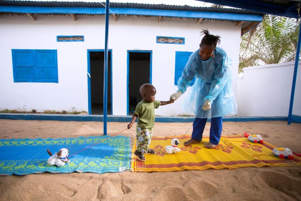 Puolitoistavuotias Tamba menetti äitinsä ebolalle ja joutui 21 päiväksi karanteeniin tartuntavaaran vuoksi. Ebolasta selvinnyt Rose Komano leikitti Tambaa UNICEFin tukemassa keskuksessa Guineassa tammikuussa 2015.
