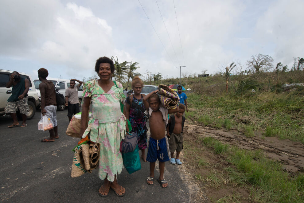 Myrskytuhoja pakeneva perhe kantoi tavaroitaan Vanuatun pääkaupungin Port Vilan laitamilla sunnuntaina 15. maaliskuuta.