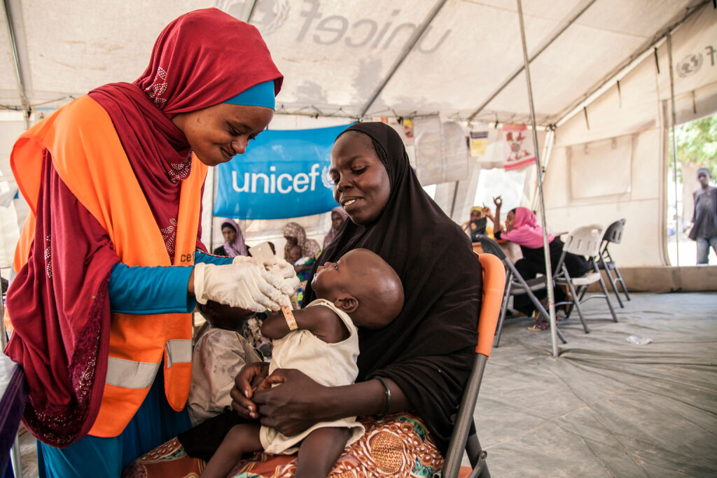 UNICEFin ravitsemusasiantuntija Aishat Abdullahi arvioi Umara Bukarin kuntoa. 7 kuukautinen Umara painoi vain 4,2 kiloa saapuessaan klinikalle Pohjois-Nigeriassa. Aliravittu lapsi sai apua klinikalla ja painaa nyt 5,1 kiloa. Kuva: UNICEF/Vittozzi
