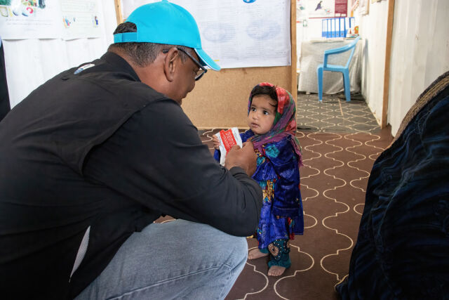 Kuvassa Afgaanilapsi saa ravitsevaa maapähkinätahnaa UNICEFin työntekijältä aliravitsemuksen hoitoon pakolaisleirillä Afganistanissa
