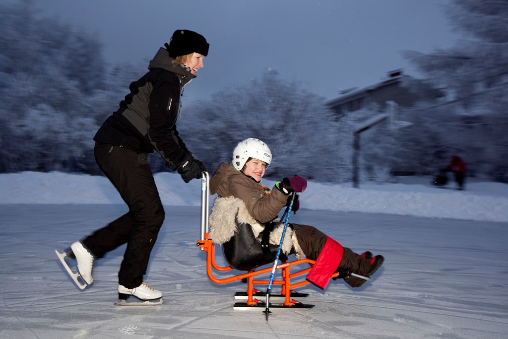 Lapsi ja ohjaaja talvileikeissä.